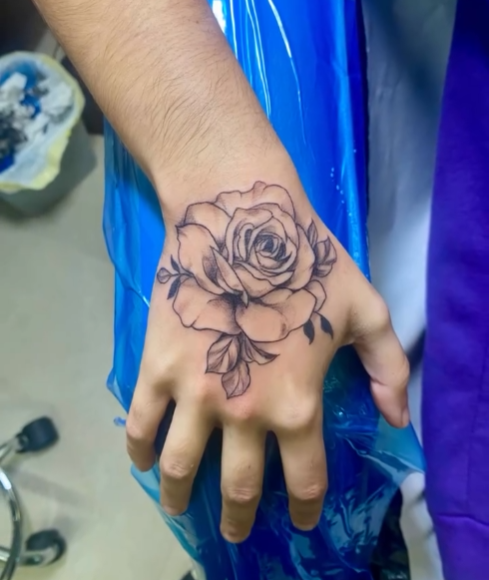 Tatouage rose sur la main — fine line — Blackthorn Tattoo Campos Majorque