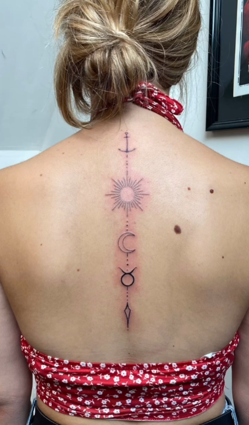 Tatouage soleil lune croix — colonne vertébrale — Blackthorn Tattoo Campos Majorque